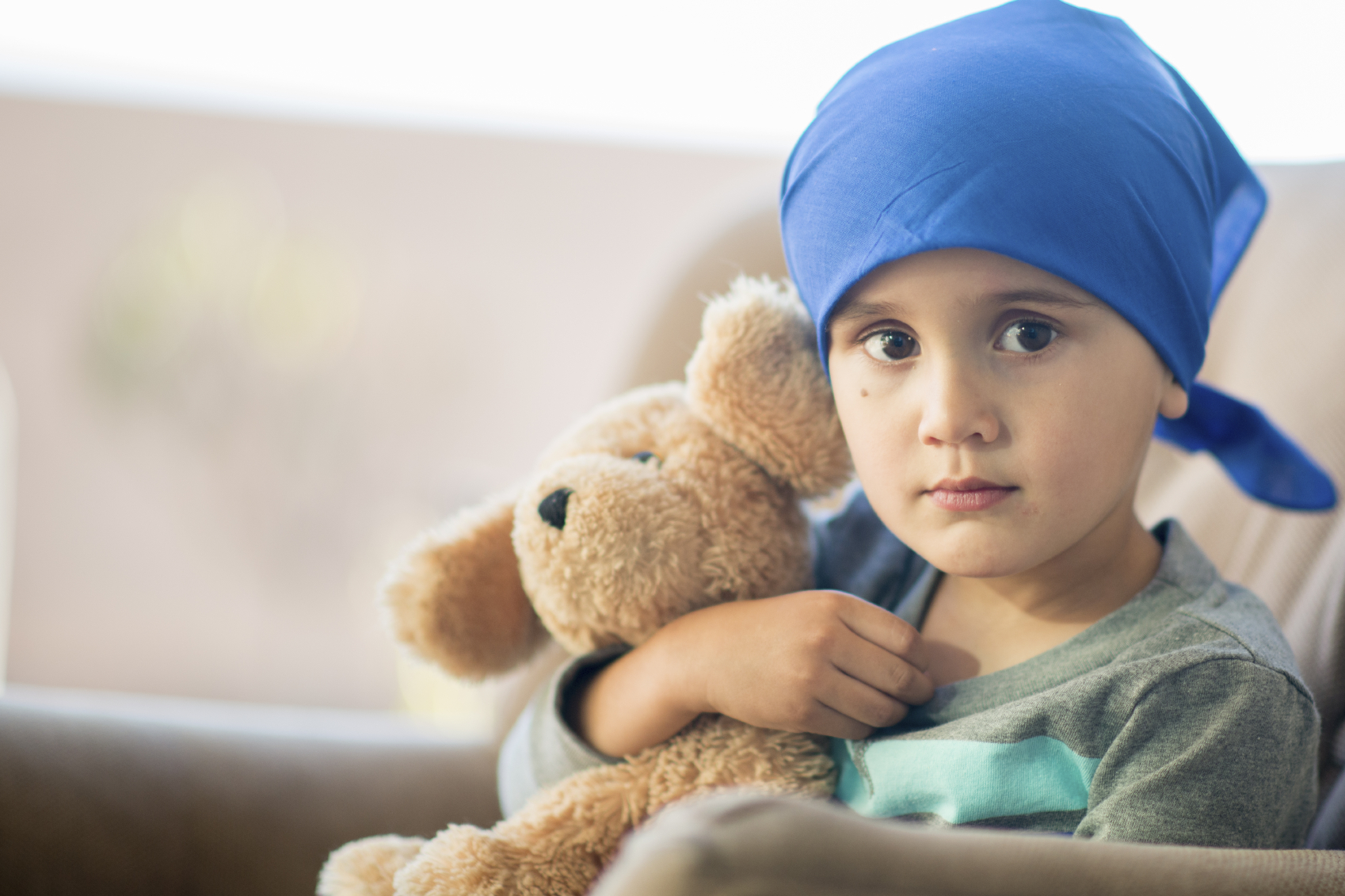 Little boy and his teddy bear after a chemotherapy treatment